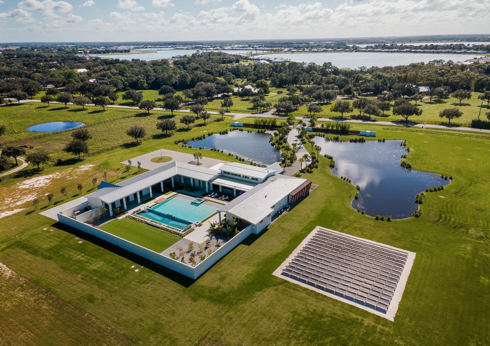 Aerial view of a completed Voigt build: house, pool, drive and solar array on an open site
