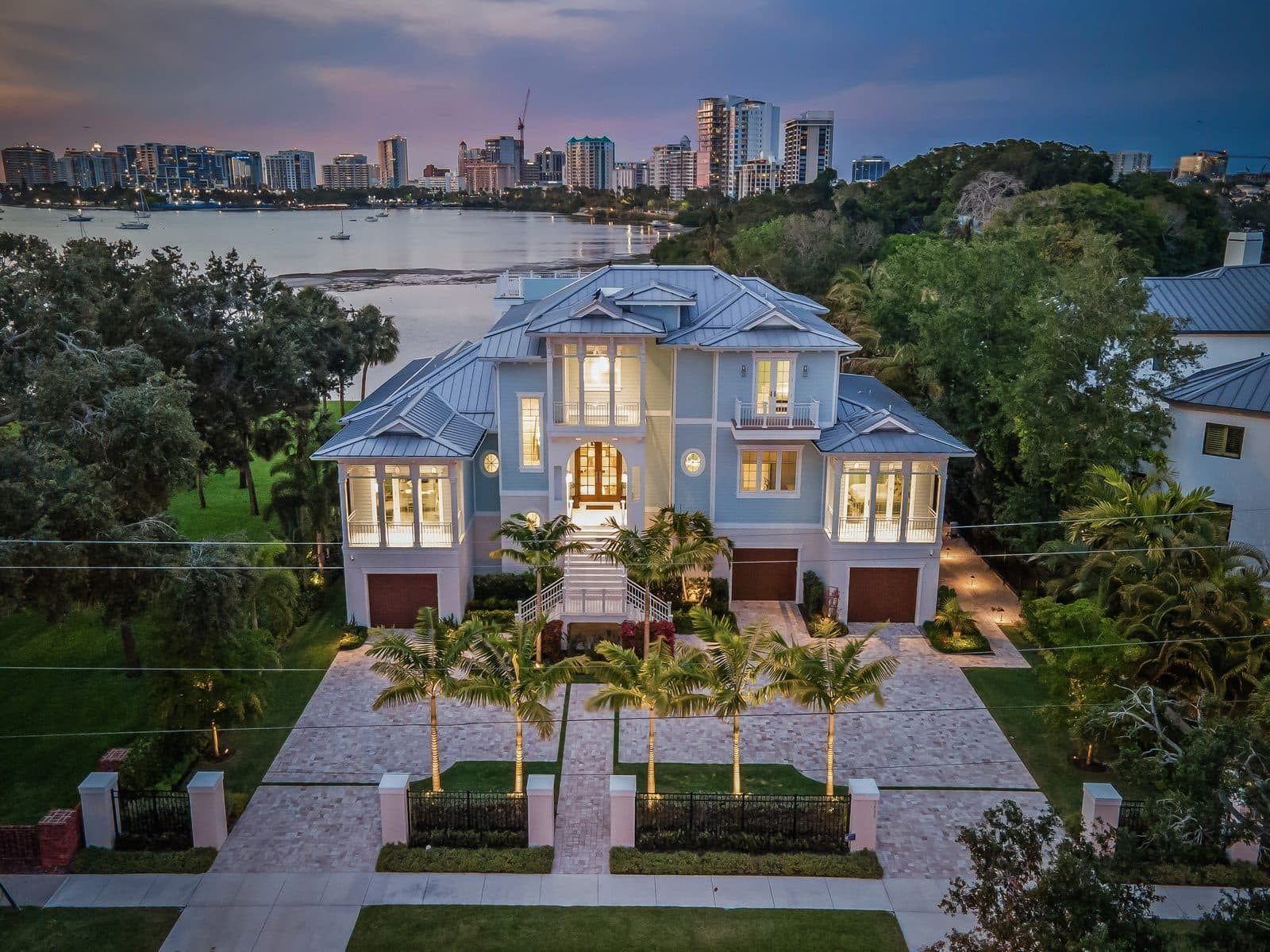 Bayfront Blues: front elevation at dusk, lit from within, with the bayfront skyline beyond