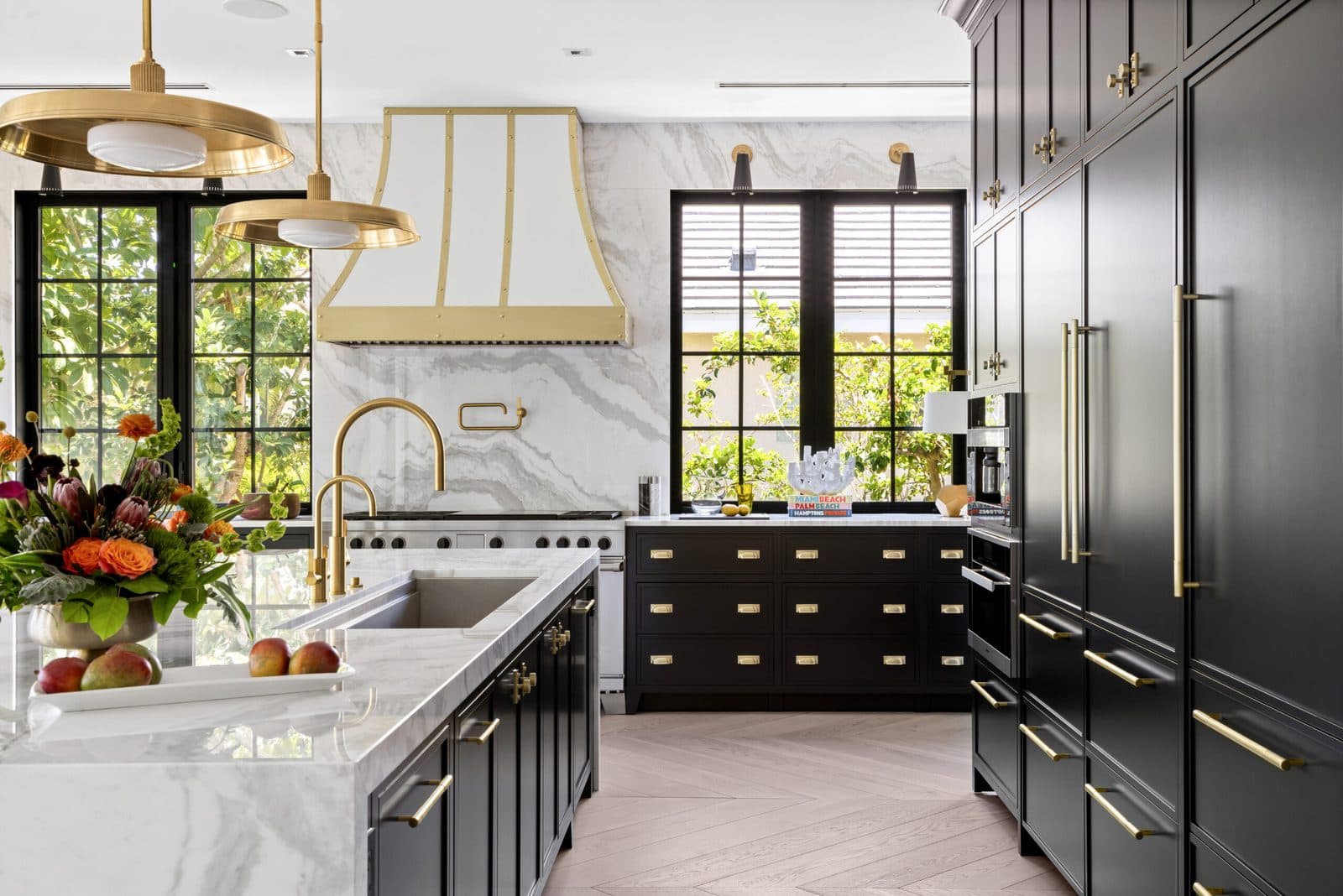 Bird's Nest: kitchen with dark cabinetry, a marble backsplash and steel-framed windows onto the garden